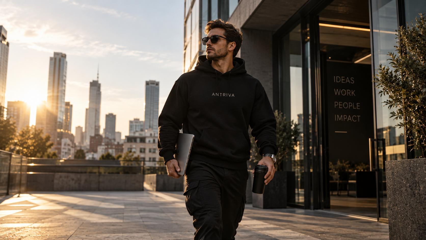 Model in schwarzem ANTRIVA Oversized-Hoodie vor urbaner Skyline